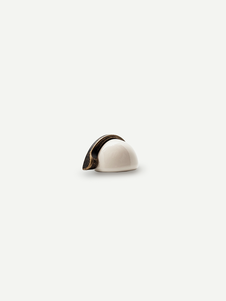 Half-moon dresser drawer knob in luxury brass and ceramic finish.