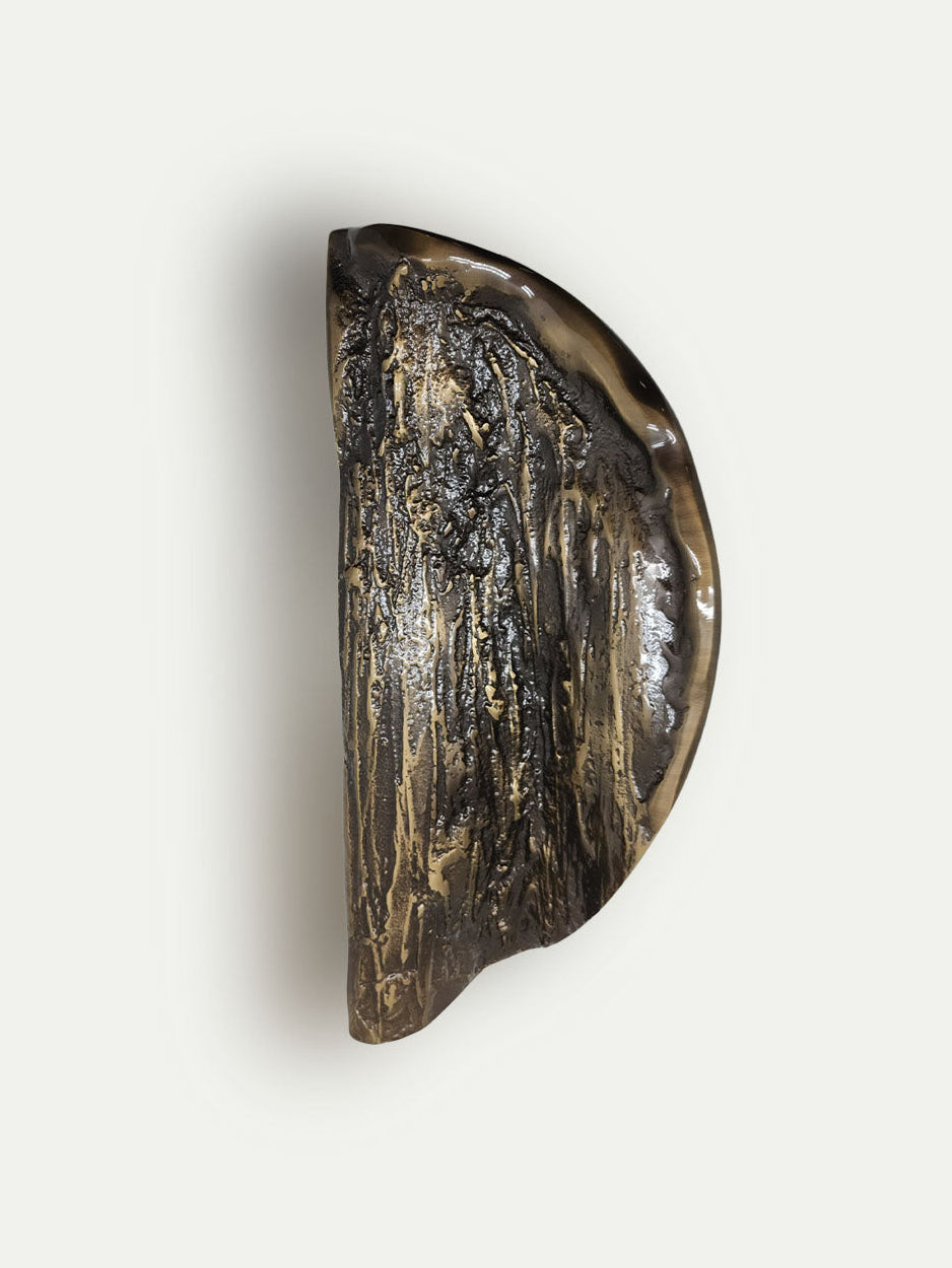 Designer dual door handles in solid brass with textured folded pattern for luxury interiors in bronze finish.